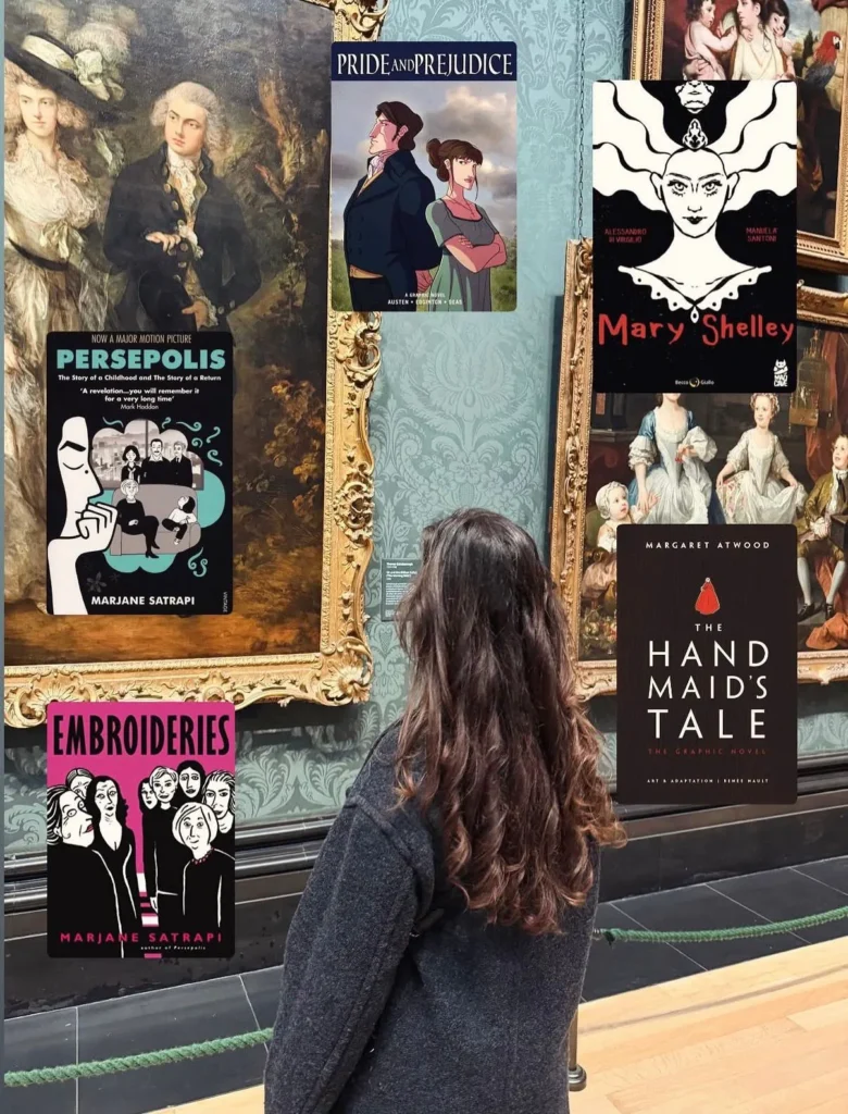 Müzede tablolar önünde grafik roman kapakları — Embroideries, Persepolis, Pride and Prejudice, Mary Shelley, The Handmaid's Tale
